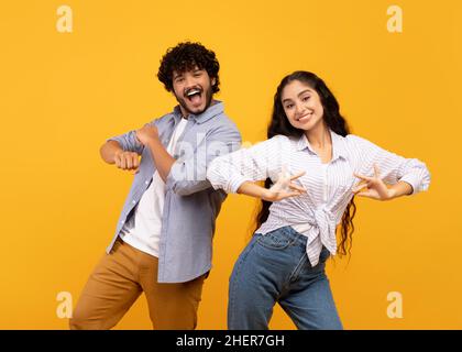 Having fun. Joyful young indian couple dancing and fooling around, enjoying favorite national music together Stock Photo