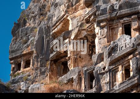 fragment of famous complex of rock tombs in the ruins of Myra with reliefs on the cliff Stock Photo