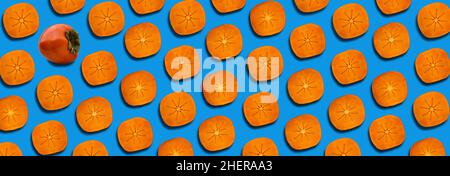 Pattern of slices ripe orange persimmon on a blue background