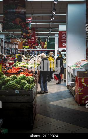 Chisinau, Moldova - October 17, 2021: Inside a supermarket. Shoppers wearing protective masks at the vegetables section of a Vellmart supermarket. Stock Photo