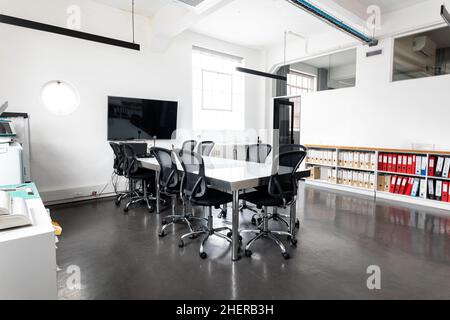 Interior of modern conference room with table and swivel chairs, copy space Stock Photo