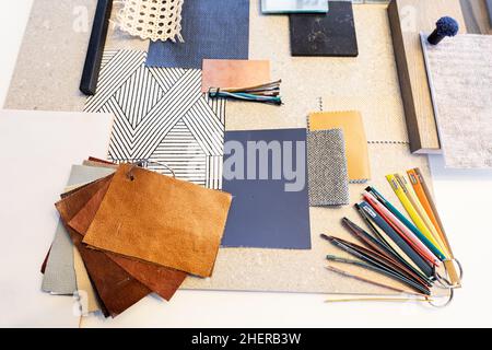 High angle view of various patterned fabric swatches and work tools on table in office Stock Photo
