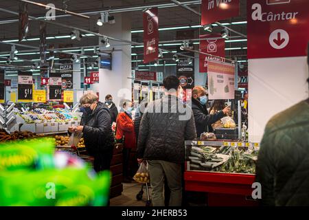 Chisinau, Moldova - October 17, 2021: Inside a supermarket. Men and women wearing medical masks buy vegetables from the self-service section of the Ve Stock Photo