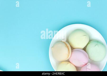 Plate with tasty marshmallows looks like macaroons on blue background. Marshmallow concept Stock Photo
