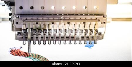 Digital textile industry. Modern computer programmable embroidery machine in garment industry Stock Photo