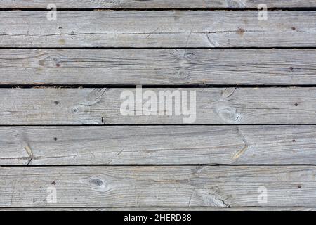Texture of gray weathered wood planks placed horizontally in sunlight. Stock Photo