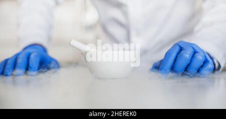 Chemist performs an experiment with liquid nitrogen in laboratory mortar with pestle Stock Photo