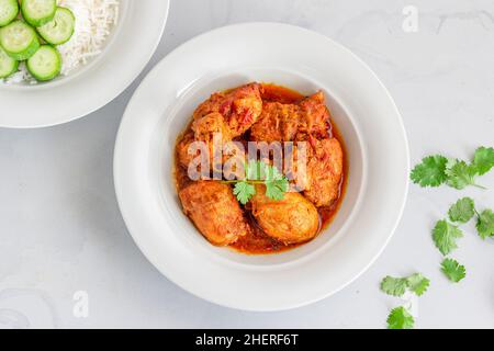 Indian Chicken Curry in a Bowl with Rice and Cucumber Stock Photo