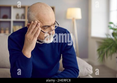 Older man with serious and thoughtful expression looks away thinking about something important. Stock Photo