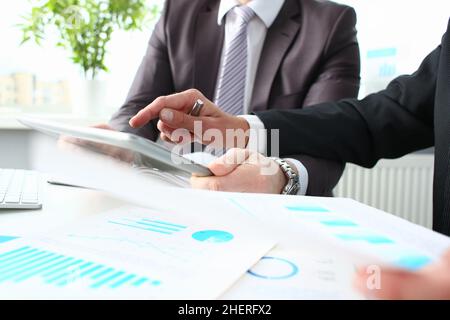 Two businessmen looking and studying analytics and business statistics Stock Photo