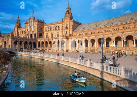 Boats in Plaza de Espana Seville, view of people walking through the historic Plaza de Espana in Seville (Sevilla) on a summer afternoon, Andalucia, S Stock Photo