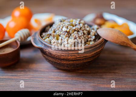 traditional dish kutya groats with fruits and raisins for christmas holiday for dinner with tangerines and honey Stock Photo