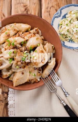Ukrainian dumplings with fried bacon and onions in a rustic style Stock Photo