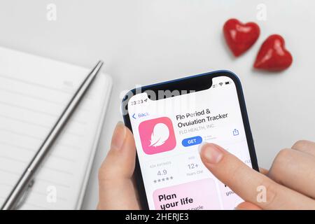 Kharkov, Ukraine - January 10, 2022: Flo Period and Ovulation tracker app icon closeup. Woman uses the application on Apple iPhone 12 Stock Photo