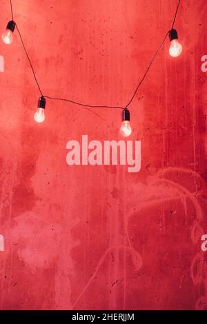 texture on red and yellow painted wall. red background with light bulbs, space for text. grunge aged backdrop. Valentine or wedding card pattern. Stock Photo