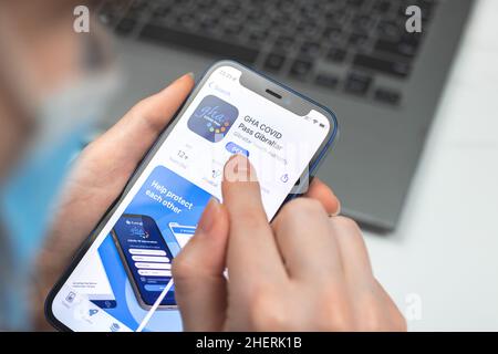 Kharkov, Ukraine - January 10, 2022: GHA COVID Pass Gibraltar app icon closeup. Woman uses the application on Apple iPhone 12 Stock Photo