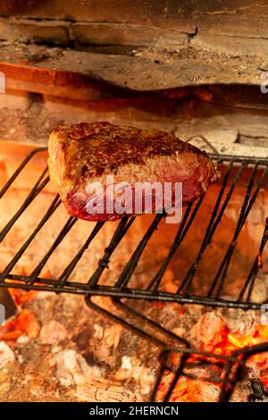 Tasty beef steak with blood on a charcoal grill. Delicious medium rare beef fillet roasted on a grid Stock Photo
