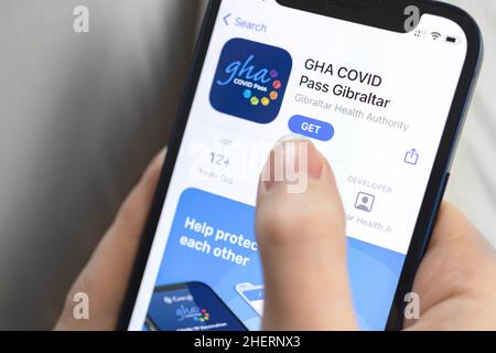 Kharkov, Ukraine - January 10, 2022: GHA Covid-19 pass app icon closeup. Woman with application on Apple iPhone 12 Stock Photo