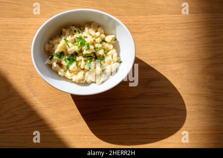 original austrian cheese spaetzle dumplings with wild chive in white bowl Stock Photo