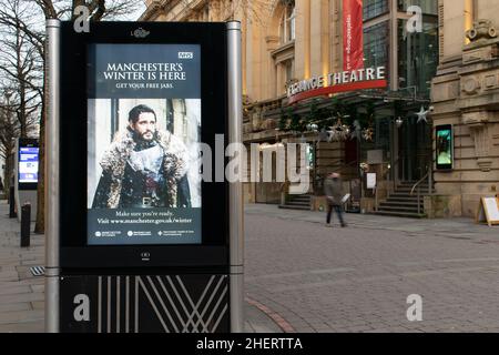 Loop advert for free NHS jabs in winter outside the Royal Exchange Theatre on St Anns Square, Manchester, UK Stock Photo
