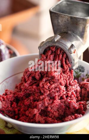 Delicious ground minced beef meat for burgers. Vintage meat grinder. Meat close-up Stock Photo