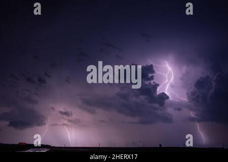 Lightning bolt strike from a thunderstorm with storm clouds Stock Photo