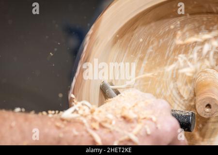long spiral wood shavings while making a wooden bowl on turnery machine Stock Photo