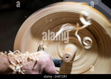 wood shavings in motion while turnery of a wooden bowl with chisel Stock Photo