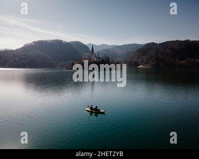 2 people doing sports, kayaking on lake bled in front of island bled in Slovenia Stock Photo