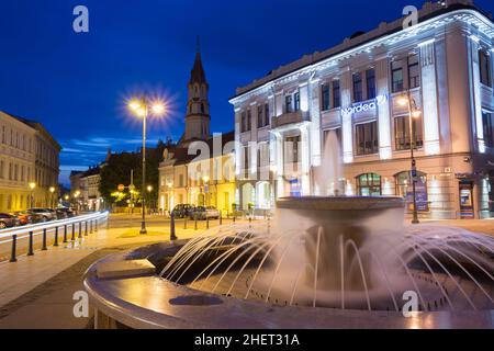 Vilnius Lithuania. Gray Marble Fountain, Water Jets On Illuminated Rotuses Square, Summer Blue Sky Stock Photo
