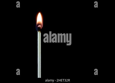 Upright burning match isolated on a black background Stock Photo