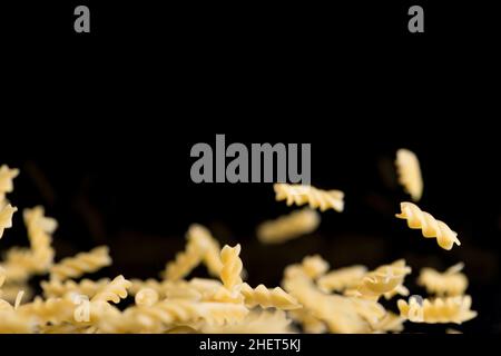 sveral flying spiral noodles on black background Stock Photo