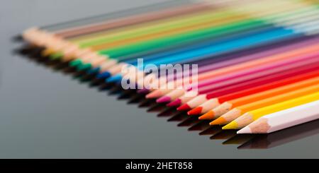arranged colored wood pencils lying on black background Stock Photo