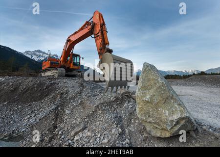 huge shovel excavator standing on gravel hill with stone rock Stock Photo