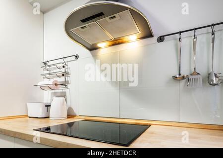 Extractor hood and ceramic hob in kitchen of vacation rental apartment Stock Photo