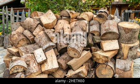 Cut wood logs stored in a storage yard. This woodpile are chopped and saved to burn in a stove during winter. Stock Photo