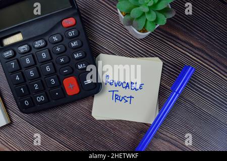 Revocable Trust write on sticky notes isolated on Wooden Table. Stock Photo