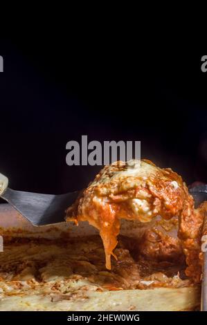 lasagna in an aluminum pan, spatula taking a piece of the pan, selective  focus Stock Photo - Alamy