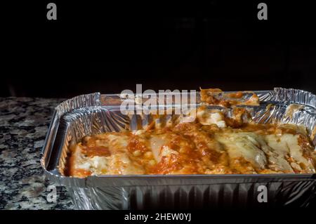 https://l450v.alamy.com/450v/2hew0yj/lasagna-in-an-aluminum-pan-spatula-taking-a-piece-of-the-pan-selective-focus-2hew0yj.jpg