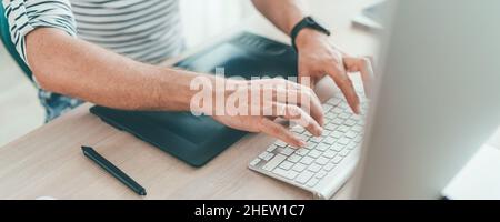 Writer typing modern computer keyboard writing novel sitting at the white wood table. Distance or freelance work on worldwide quarantine time concept Stock Photo