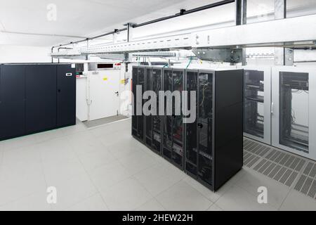 small air conditioned server room with black racks and climate control unit Stock Photo