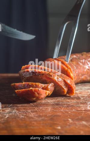 Sliced smoked calabrese sausage in a wooden table,copy space Stock Photo