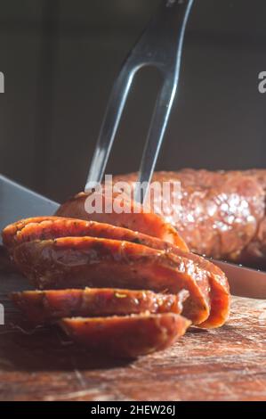 Sliced smoked calabrese sausage in a wooden table,copy space Stock Photo