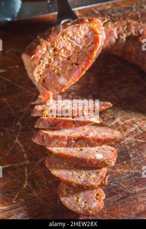 Sliced smoked calabrese sausage in a wooden table,copy space Stock Photo