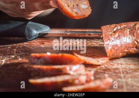 Sliced smoked calabrese sausage in a wooden table,copy space Stock Photo