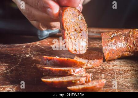 Sliced smoked calabrese sausage in a wooden table,copy space Stock Photo