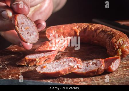 Sliced smoked calabrese sausage in a wooden table,copy space Stock Photo