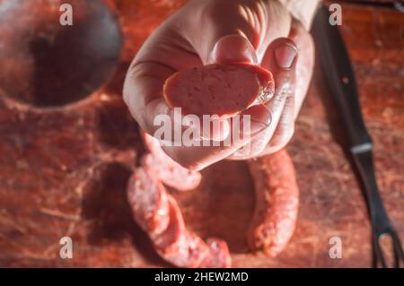 Sliced smoked calabrese sausage in a wooden table,copy space Stock Photo