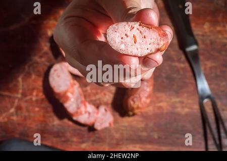 Sliced smoked calabrese sausage in a wooden table,copy space Stock Photo