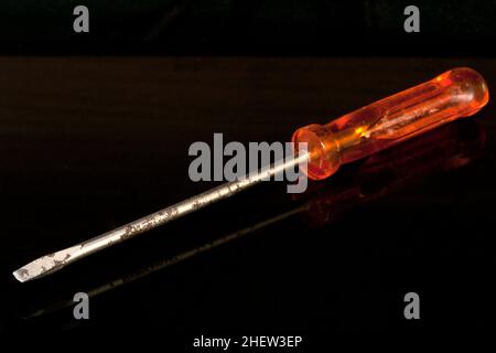 rusty orange screwdriver isolated on black background Stock Photo